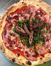 Pizza saporita con bacon croccante, straccetti di burger grigliati, rucola fresca e salsa barbecue