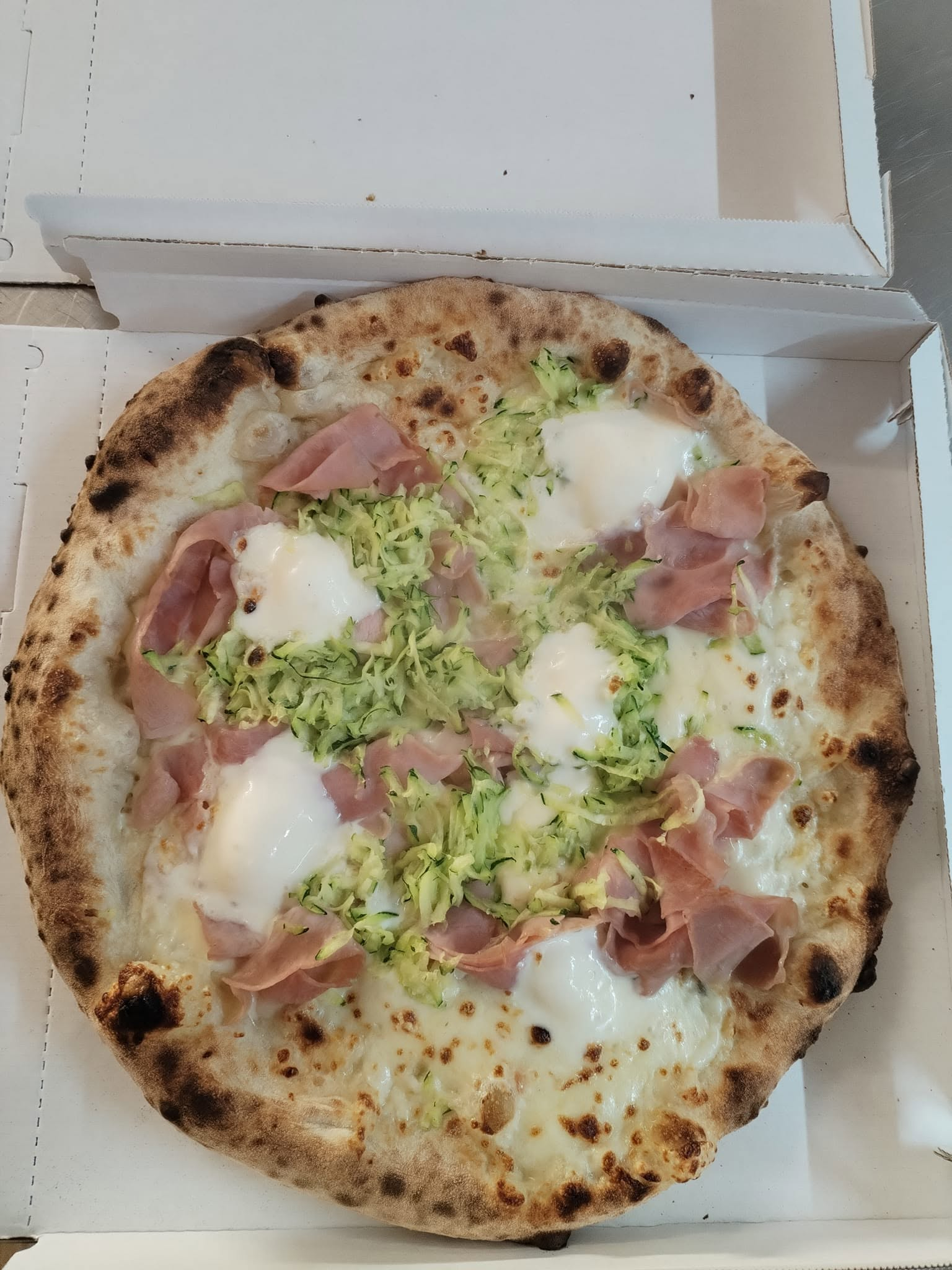 Pizza bianca con julienne di zucchine fresche, burrata campana e fette di prosciutto cotto